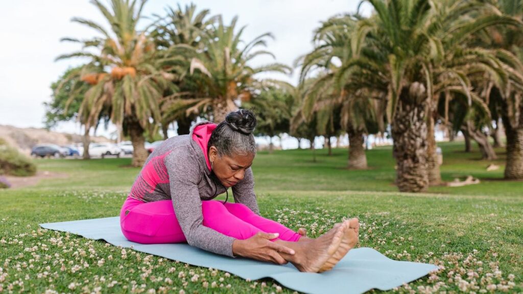 Femme assise en flexion avant sur un tapis