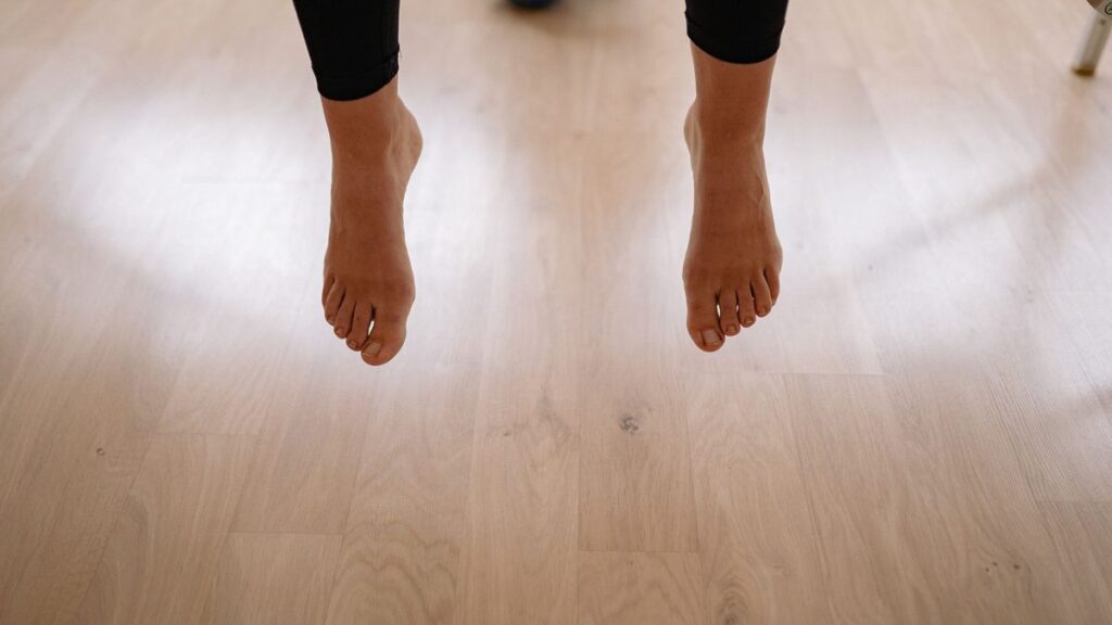 Pieds nus posés sur un parquet clair