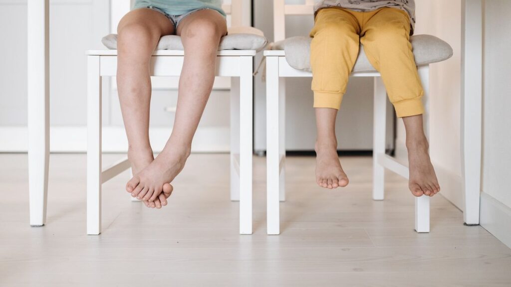 Pieds posés à plat sur le sol devant une chaise